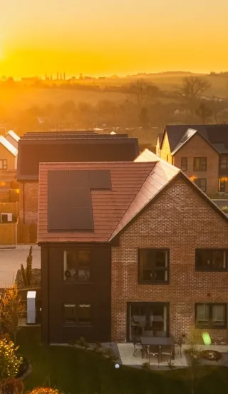 Sunset over new build homes on the Hollymead Square development by Hill