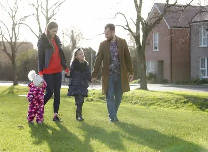 Young family walking in a park at Keepers Green