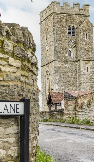 View of a historic church on a narrow village road