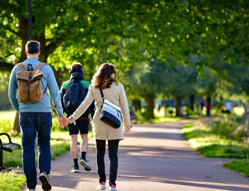 People walking through a tree lined park