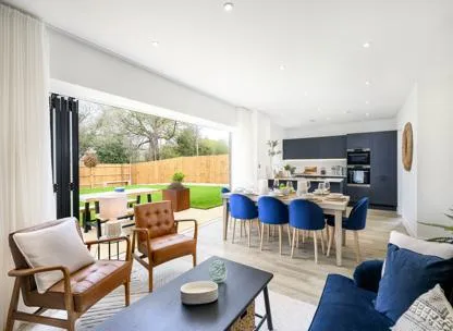 Open plan kitchen, living and dining room with open french doors onto garden at Millside Grange